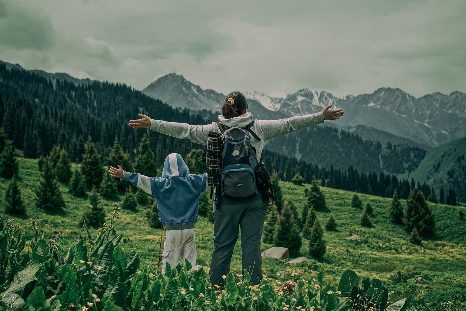 A parent and child walking a mountain trail together