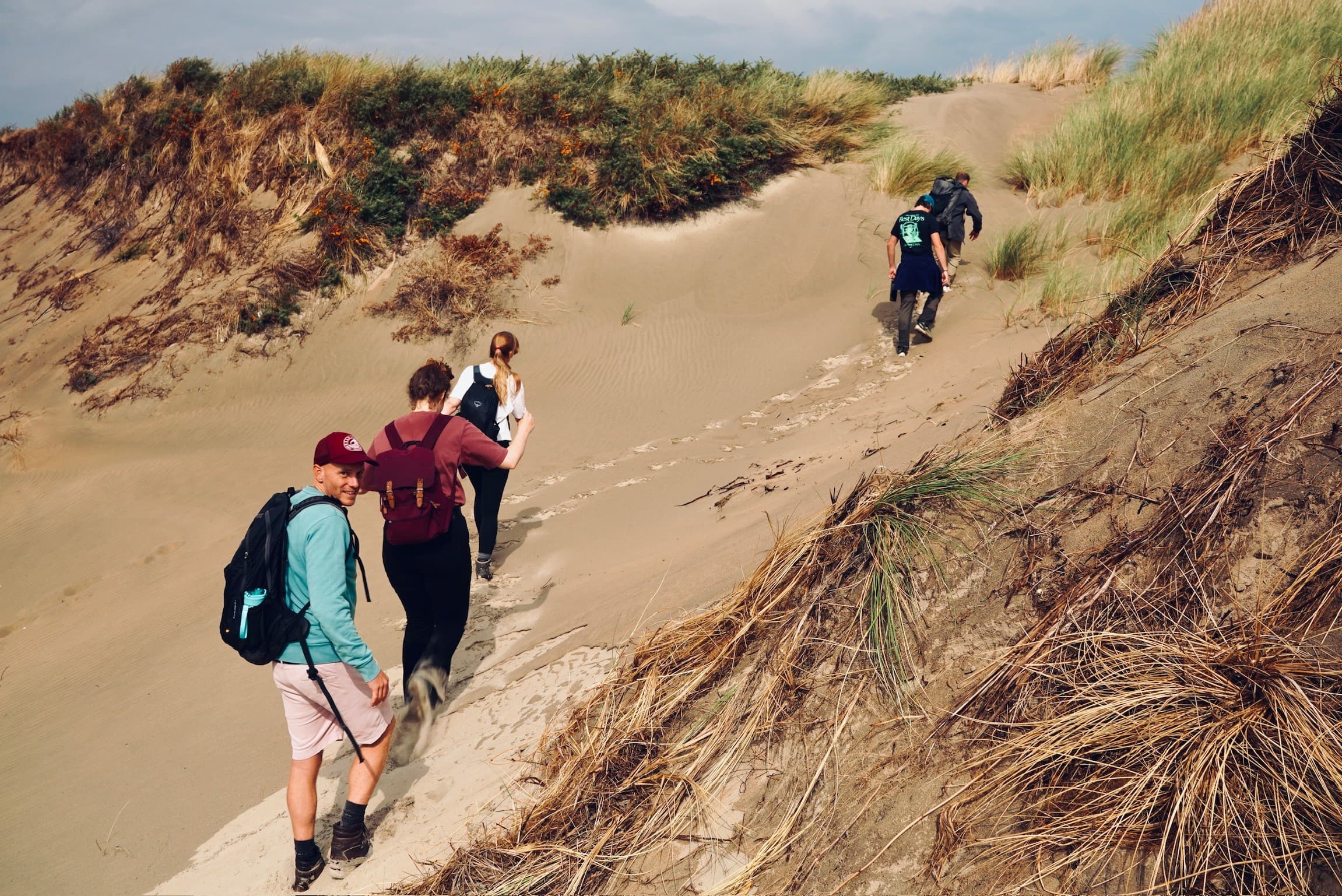 The group walking out across the dunes