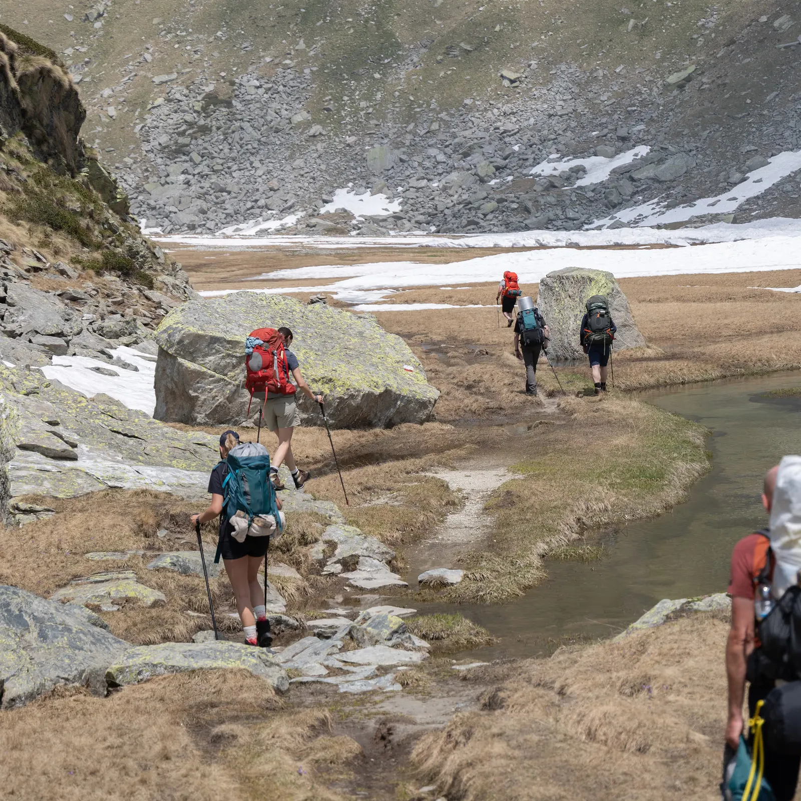 A walker on a rocky alpine trail with Monte Rosa behind